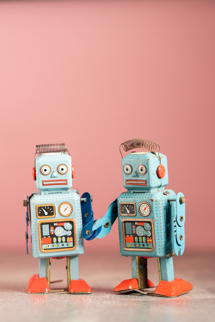 Foto juguetes robot vintage en mesa rosa