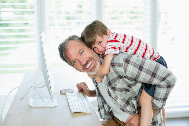 Foto juguetón, padre e hijo, trabajando en equipo en casa