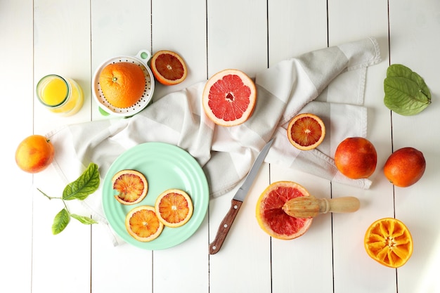 Juicing deliciosas laranjas em mesa de madeira branca