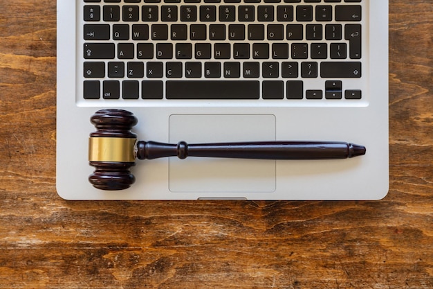 Juiz martelo em um laptop fundo de madeira vista superior conceito de leilão on-line