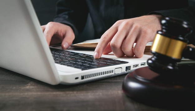 Juiz masculino digitando no teclado do laptop Justiça e direito