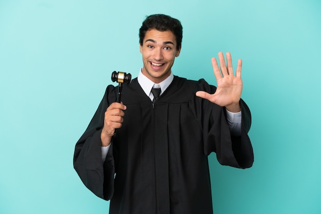 Juiz sobre fundo azul isolado contando cinco com os dedos