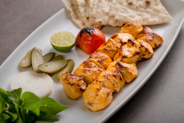 Jujeh chhicken tikka boti kabab mit brot und salat serviert in gericht isoliert auf grauem hintergrund draufsicht auf arabisches essen