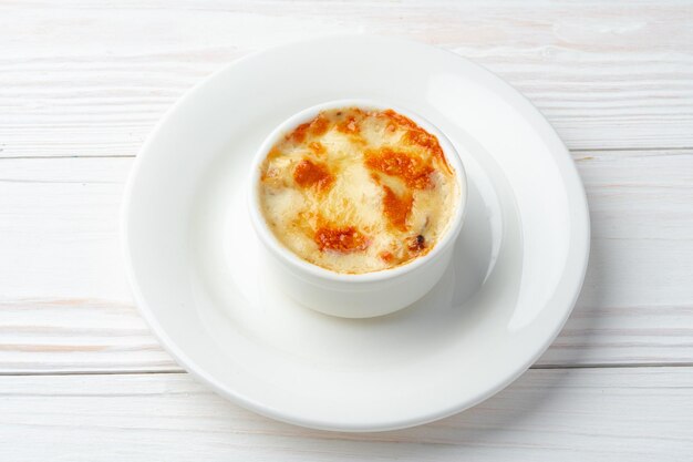 Juliana al horno con champiñones y queso encima en un plato blanco