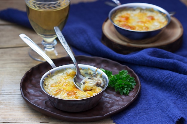 Julienne com cogumelos e molho bechamel com queijo, servido com vinho branco. Estilo rústico.