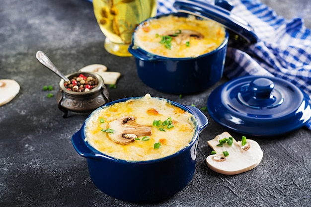 Julienne de cogumelo assado com frango e queijo em vasos.