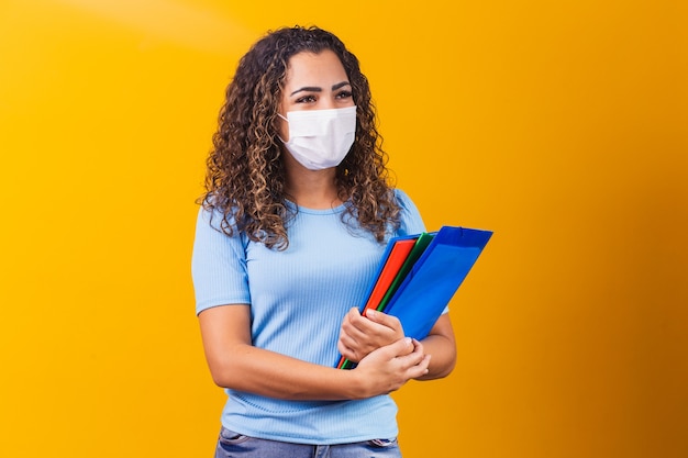 Junge Absolventen oder Gymnasiasten, die eine chirurgische Maske gegen Covid 19 tragen. Neues Normal- und Bildungskonzept