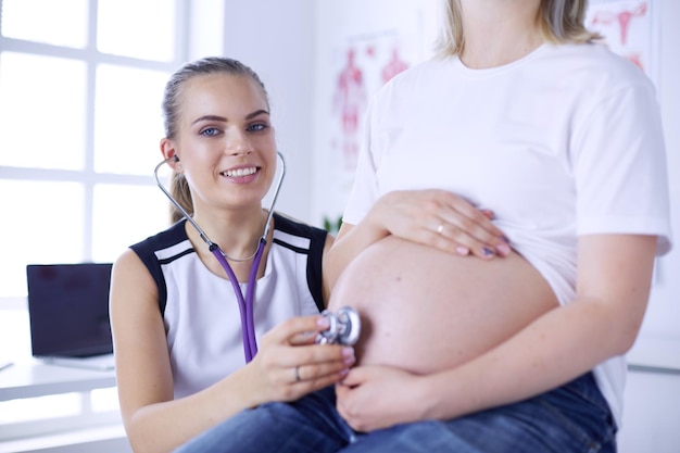 Junge Ärztin untersucht schwangere Frau in der Klinik