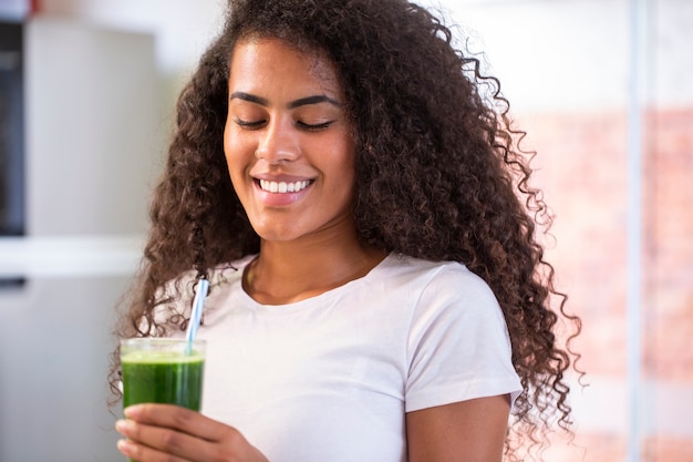 Junge afrikanische Frau genießen gesunden vegetarischen Smoothie für Gewichtsverlust und Entgiftung