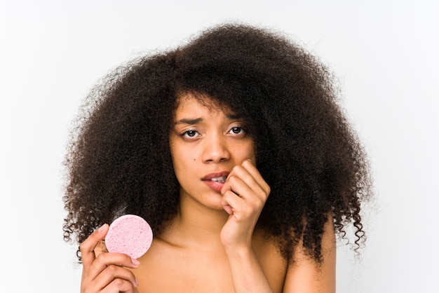 Junge Afro-Frau, die eine Gesichtsscheibe hält, isolierte beißende Fingernägel, nervös und sehr ängstlich.