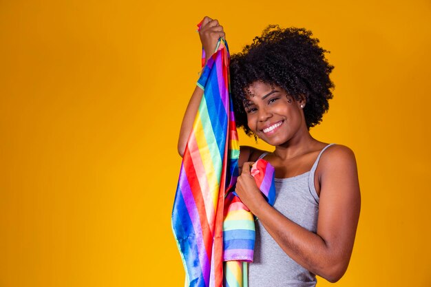 Junge afro-frau, die in ihren händen einen schwulenstolz der lgbt-flagge hält