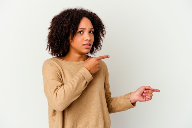 Junge Afroamerikaner gemischte Rasse Frau isoliert schockiert mit Zeigefinger auf einen Kopierraum zeigen.