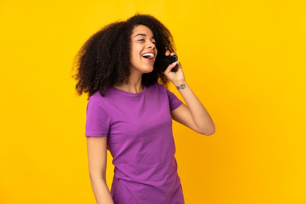 Junge Afroamerikanerfrau, die ein Gespräch mit dem Mobiltelefon hält