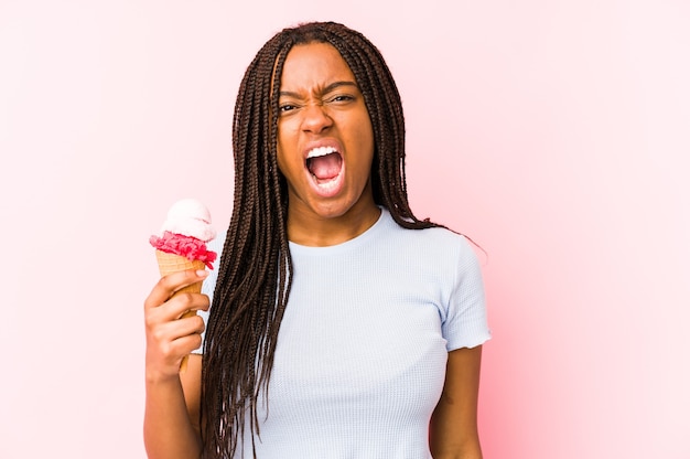 Junge Afroamerikanerfrau, die eine Eiscreme isoliert schreit, die sehr wütend und aggressiv schreit.