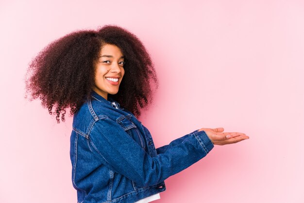 Junge Afroamerikanerfrau, die einen Kopienraum auf einer Palme hält.