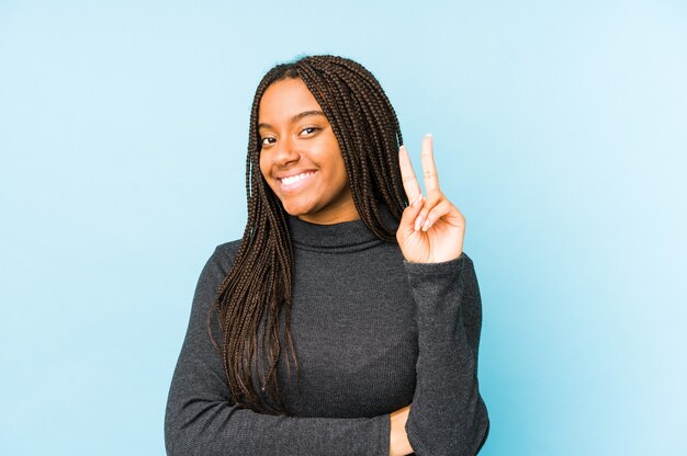 Junge Afroamerikanerfrau lokalisiert auf Blau, das Nummer zwei mit den Fingern zeigt.