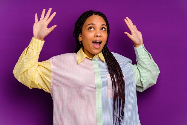 Junge Afroamerikanerfrau lokalisiert auf gelber Wand, die zum Himmel schreit und aufschaut, frustriert