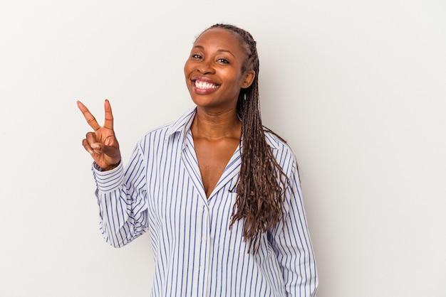 Junge Afroamerikanerfrau lokalisiert auf weißem Hintergrund, der Victory-Zeichen zeigt und breit lächelt.