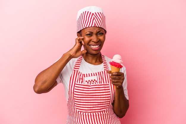 Junge afroamerikanische Eismaschine Frau mit Eis isoliert auf rosa Hintergrund Ohren mit Händen bedeckt.