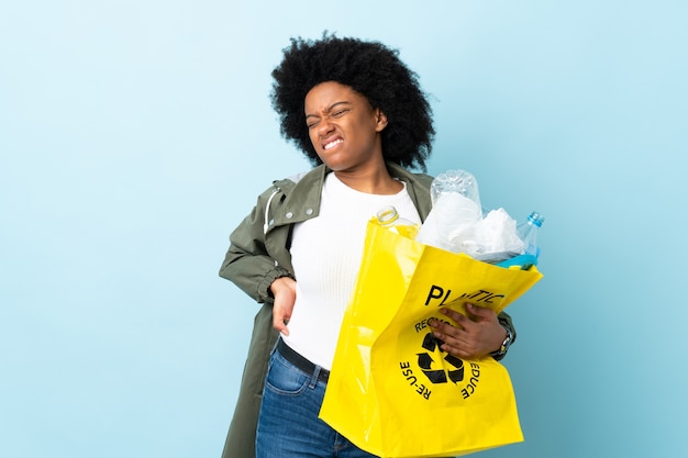 Junge afroamerikanische Frau, die einen Recyclingbeutel hält