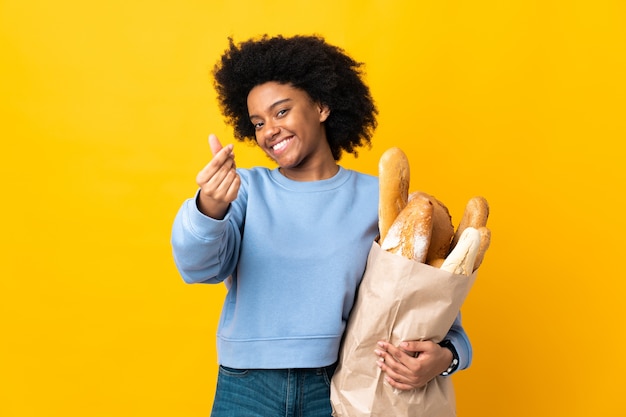 Junge afroamerikanische Frau, die etwas Brot kauft