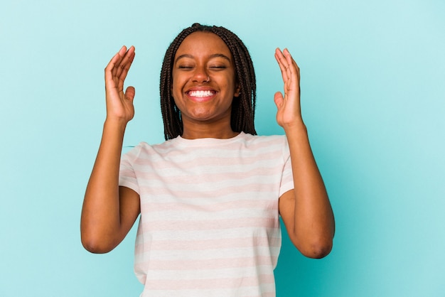 Junge afroamerikanische Frau isoliert auf blauem Hintergrund freudig viel lachen. Glück-Konzept.