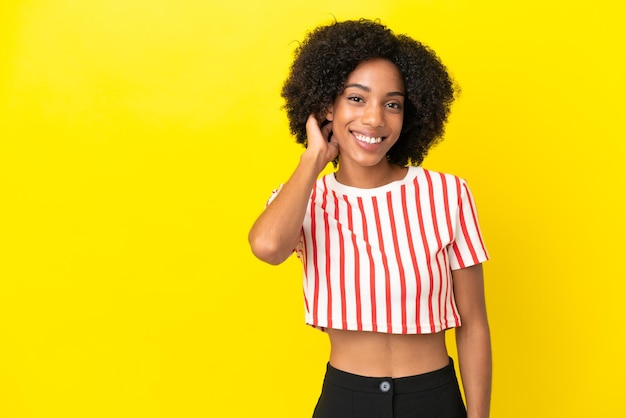 Junge afroamerikanische Frau isoliert auf gelbem Hintergrund lachen