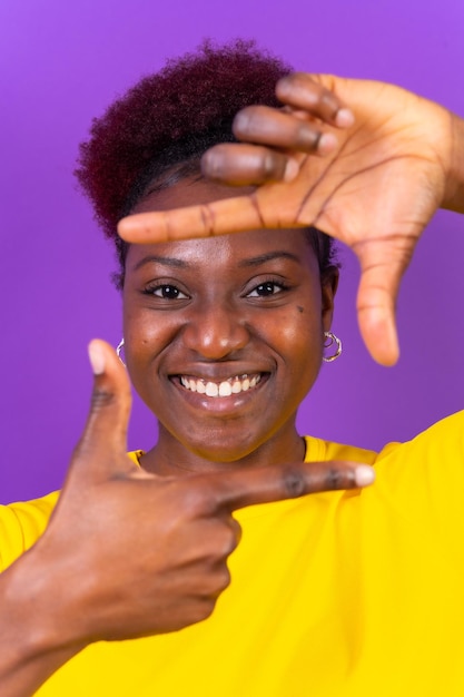 Junge afroamerikanische Frau isoliert auf violettem Hintergrund mit quadratischer Geste beim Studioshooting mit den Fingern