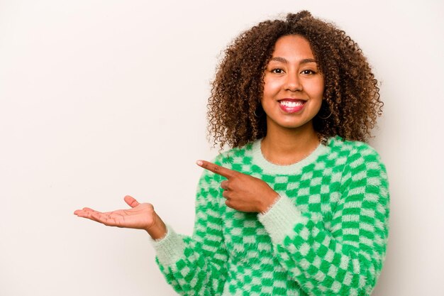 Junge afroamerikanische Frau isoliert auf weißem Hintergrund aufgeregt mit einem Kopierraum auf der Handfläche