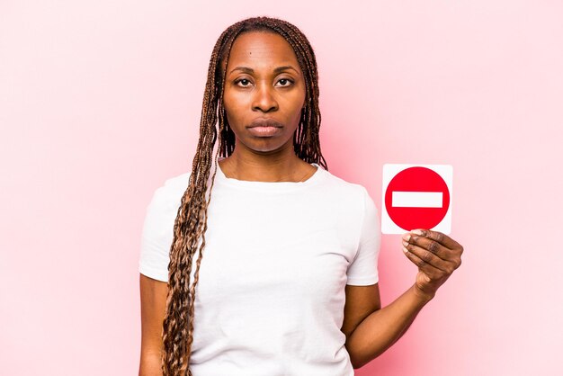 Junge afroamerikanische Frau mit einem verbotenen Schild isoliert auf rosa Hintergrund