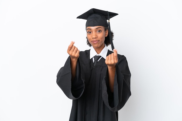 Junge afroamerikanische Frau mit Hochschulabschluss isoliert auf weißem Hintergrund, die Geldgeste macht
