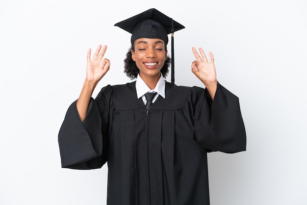Junge afroamerikanische Frau mit Hochschulabschluss isoliert auf weißem Hintergrund in Zen-Pose