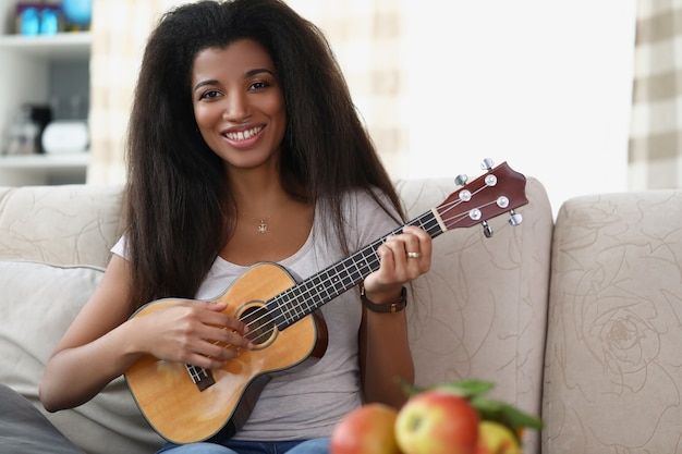 Junge afroamerikanische Frau spielt Musikinstrument Ukuleleule