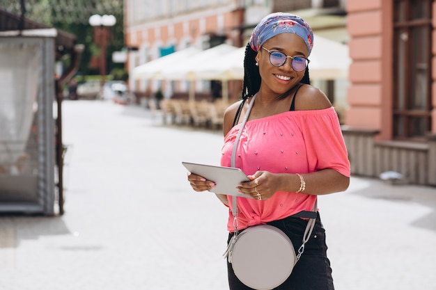 junge afroamerikanische Frau stehend und mit Tablet-Computer auf der Straße