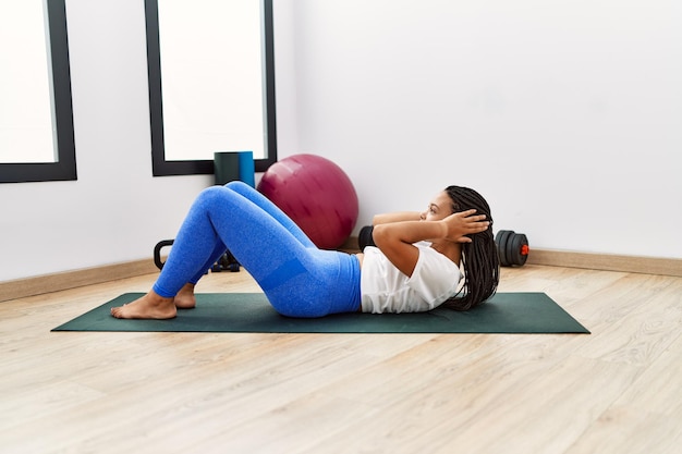 Junge afroamerikanische Frau trainiert Bauchmuskelübungen im Sportzentrum