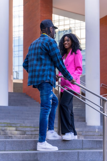 Junge afroamerikanische Frauen unterhalten sich in der Stadt auf einer Treppe