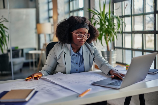 Junge afroamerikanische Geschäftsfrau, die im Büro arbeitet