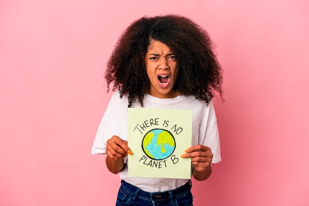 Junge afroamerikanische lockige Frau, die eine Planetenbotschaft auf einem Plakat hält, das sehr wütend und aggressiv schreit.