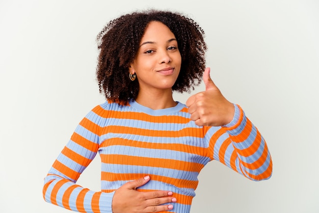 Junge afroamerikanische Mischrassenfrau berührt Bauch, lächelt sanft, Ess- und Zufriedenheitskonzept.