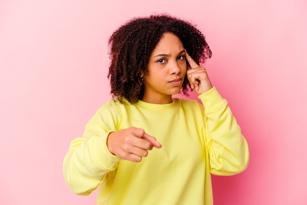 Junge afroamerikanische Mischrassenfrau isolierte Zeigetempel mit Finger, denkend, konzentrierte sich auf eine Aufgabe.