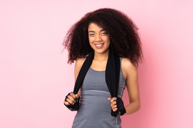 Junge afroamerikanische Sportfrau lokalisiert auf Rosa mit Sporttuch