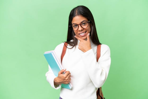 Junge afroamerikanische Studentin mit isoliertem Hintergrund, glücklich und lächelnd