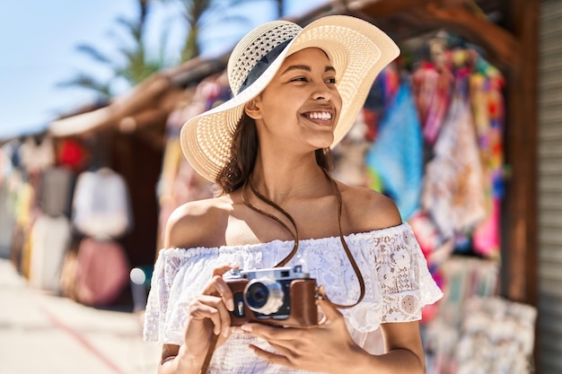 Foto junge afroamerikanische touristin lächelt selbstbewusst mit der kamera auf der straße