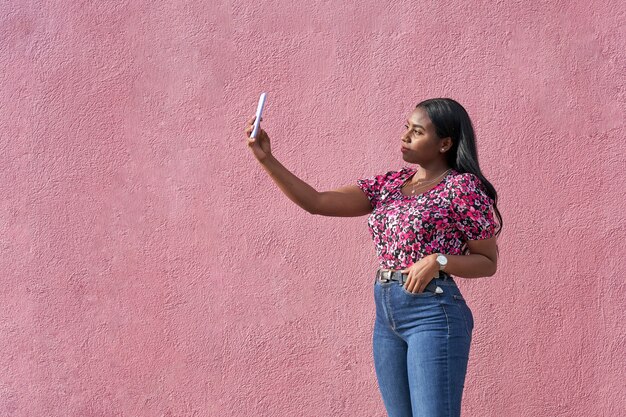 Junge Afrofrau der Schönheit, die ein selfie mit ihrem Smartphone macht