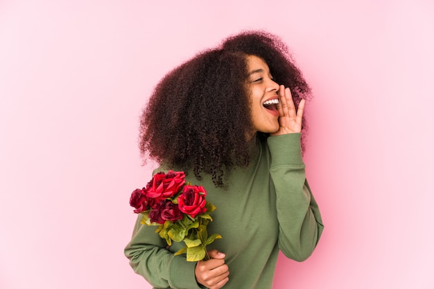 Junge Afrofrau, die Rosenblumenstrauß hält