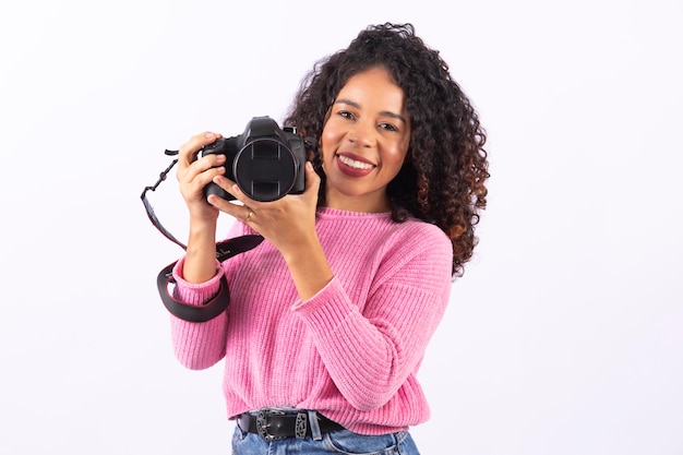 Foto junge afrofrauenfotografie auf dem weißen hintergrund, der eine fotokamera hält