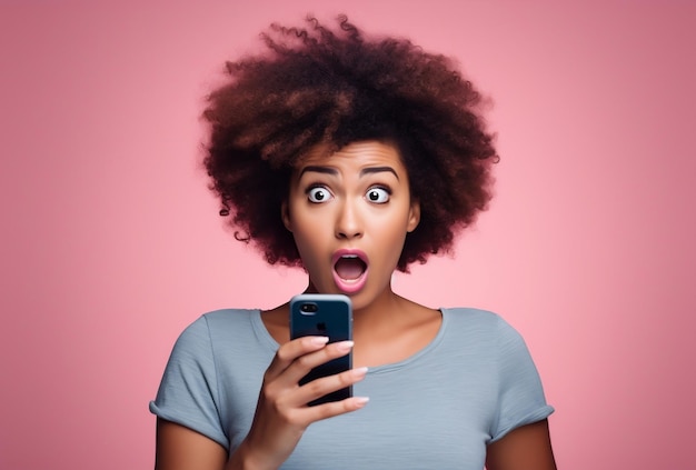 Junge afrohaarige Frau hält geschockt ihr Mobiltelefon in der Hand