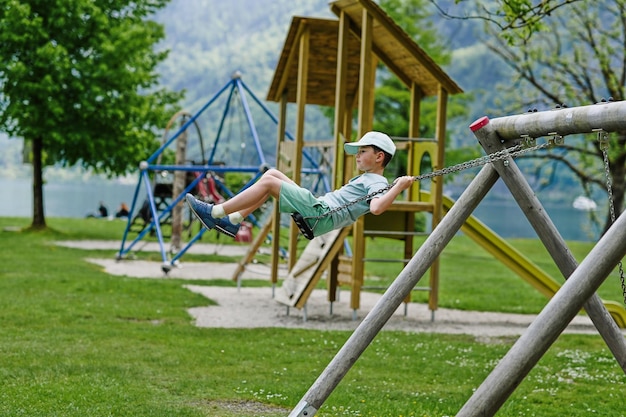 Junge am Spielplatz in Hallstatt Österreich schwingen