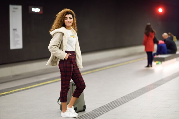 Junge arabische Frau, die ihren Zug in einer U-Bahnstation wartet.