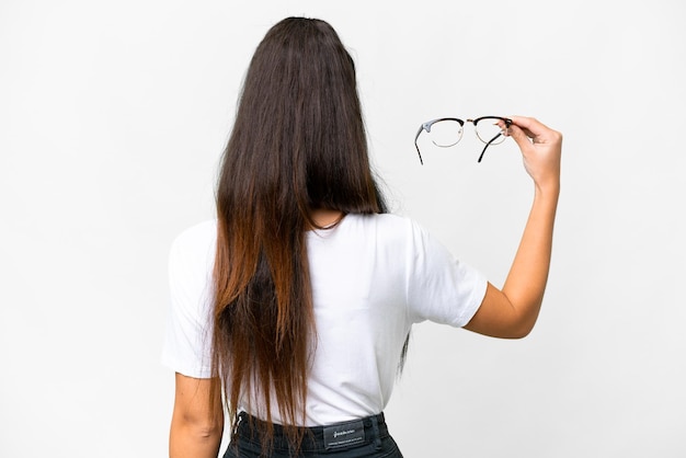 Junge arabische Frau mit Brille vor isoliertem weißem Hintergrund in Rückenposition